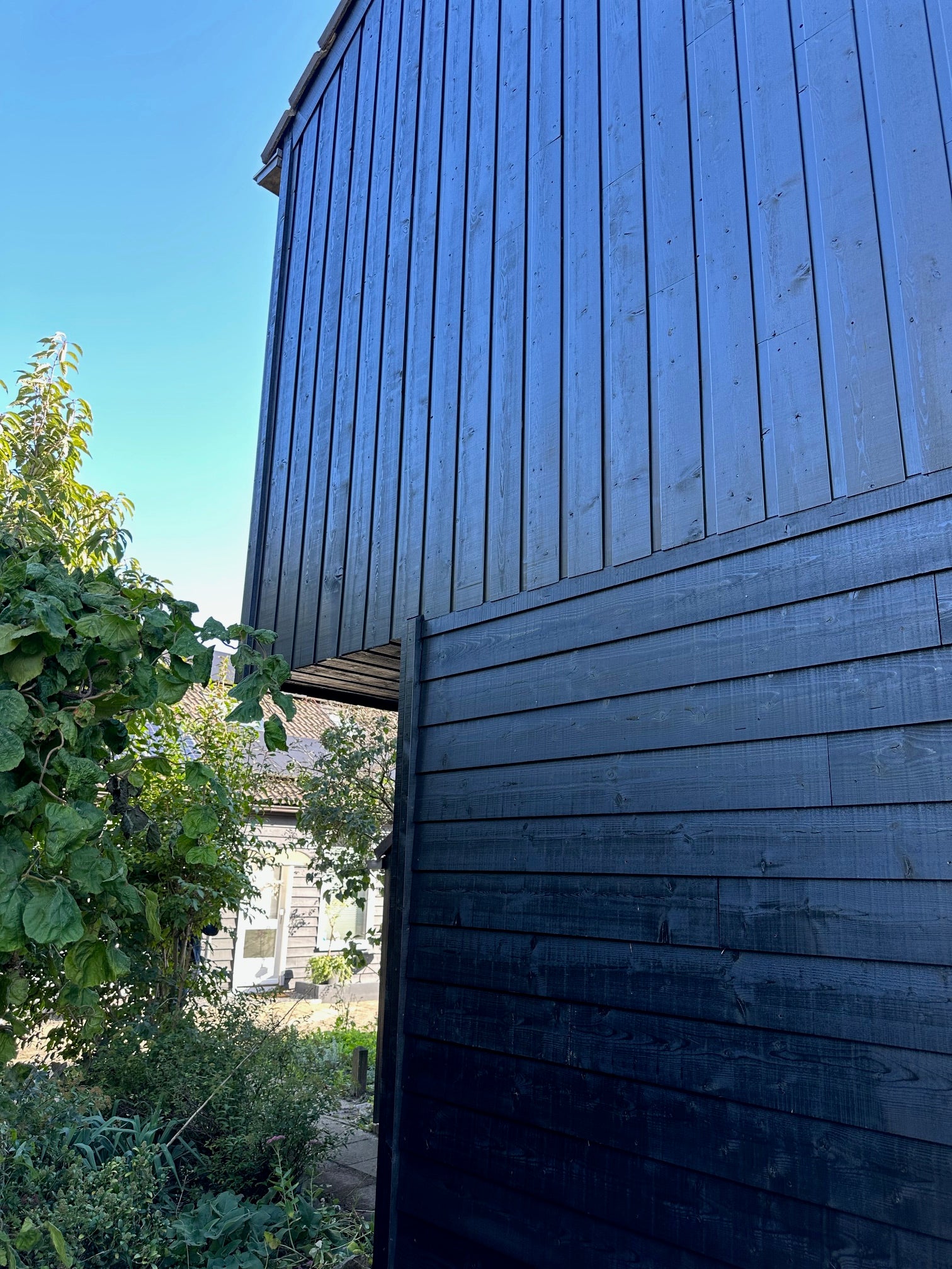 Houten gevelbekleding verticaal geplaatst, aansluitend op horizontale delen